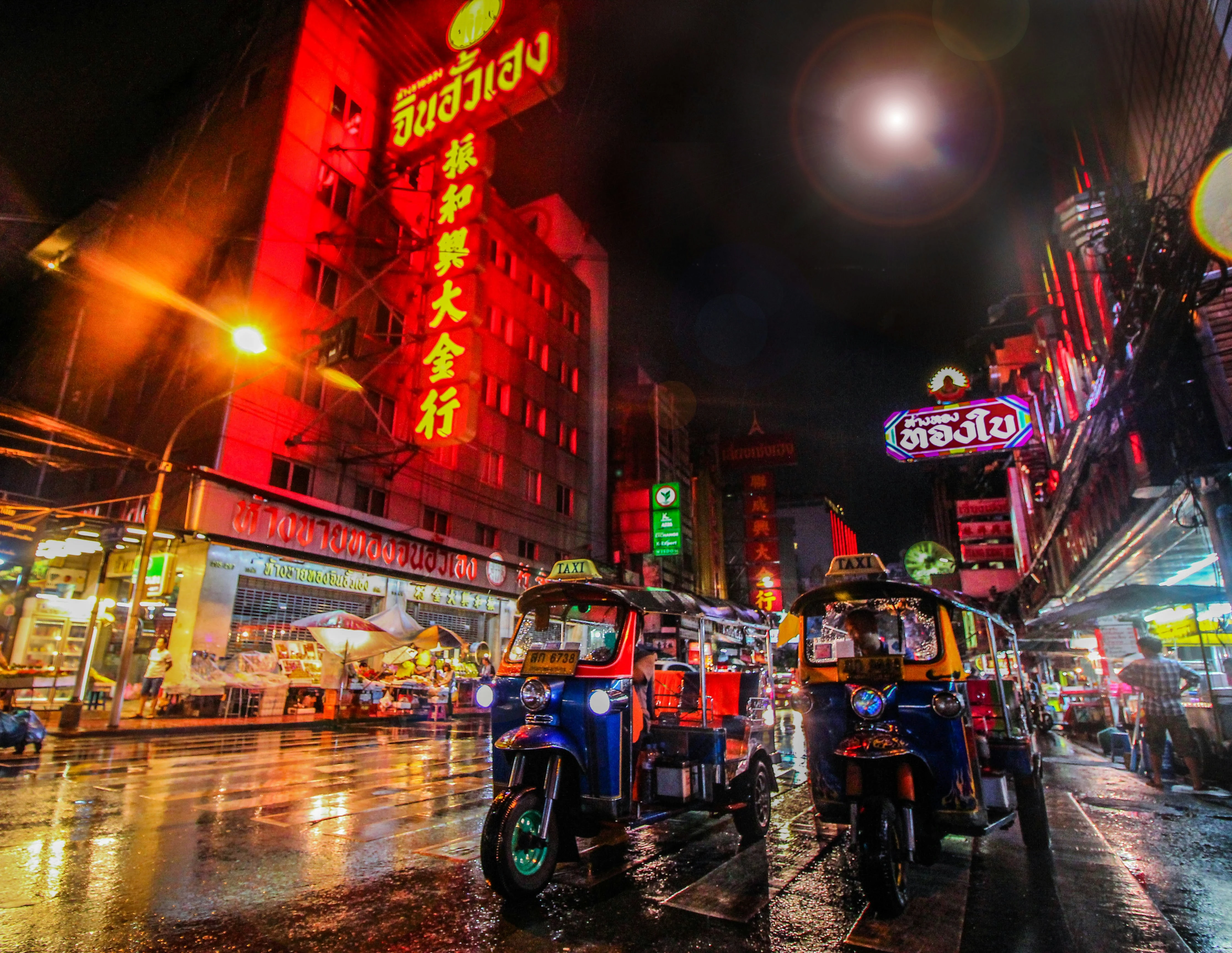 Bangkok Chinatown lit up at night with traffic and neon signs